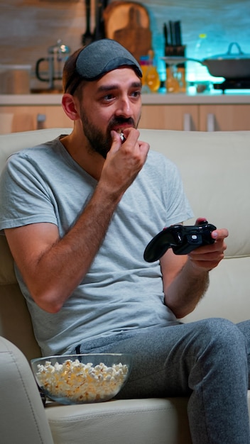 Verärgerter Profi-Gamer, der auf der Couch sitzt und Fußball-Videospiele spielt