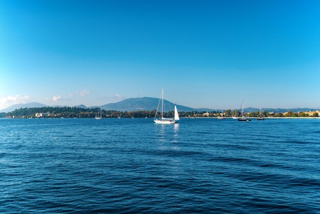 Verankertes Boot auf Meeresoberfläche gegen Korfu unter blauem Himmel