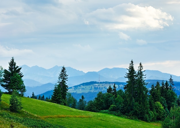 Verano en las afueras del pueblo de noche brumosa con rango de Tatra