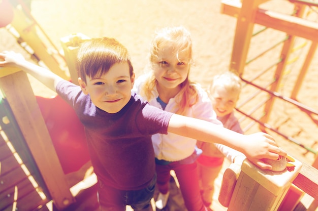 verano, infancia, ocio, amistad y concepto de personas - grupo de niños felices en el patio de recreo de niños