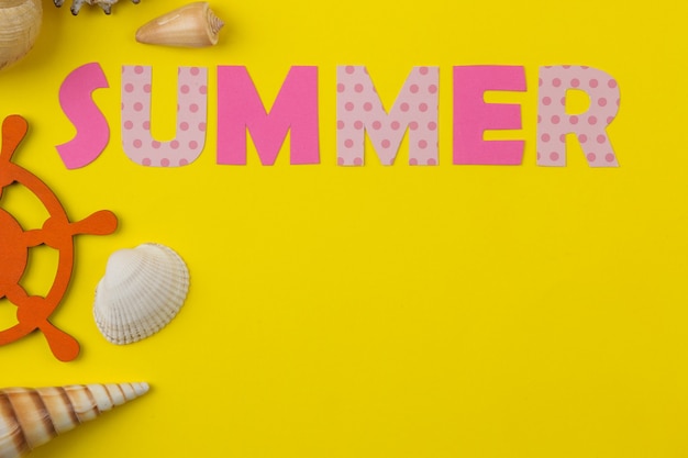 Foto verano de inscripción de papel de letras multicolores y conchas marinas. verano. relajación. vacaciones.