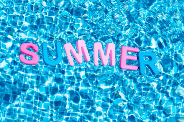 Verano de palabra en colores flotando sobre un espacio de copia de piscina