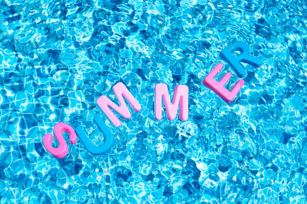 Verano de palabra en colores flotando sobre un espacio de copia de piscina
