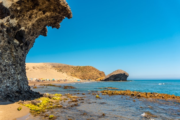Foto verano en la playa de monsul en el parque natural cabo de gata, creado con formaciones de lava erosionada en el municipio de san josé, almería