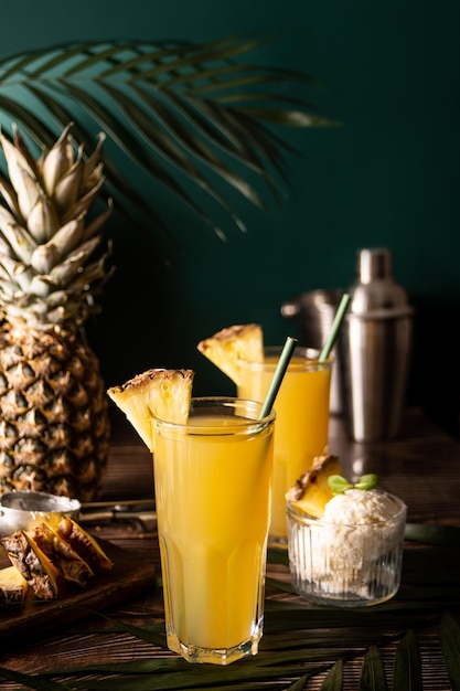 Verano refrescante bebida tropical jugo o cóctel con jugo de piña y tequila con paja de papel y helado en el fondo