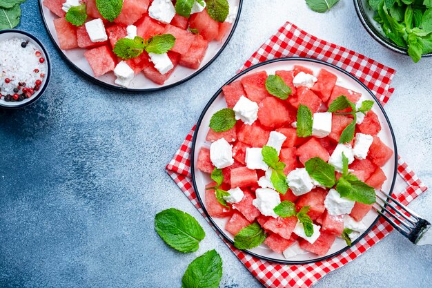 Verano refrescante jugosa ensalada de sandía con queso feta y fondo de mesa gris menta fresca vista superior espacio de copia