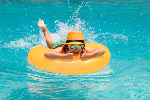 Verano relajar a los niños nadando en un anillo flotante en la piscina retrato de verano para niños