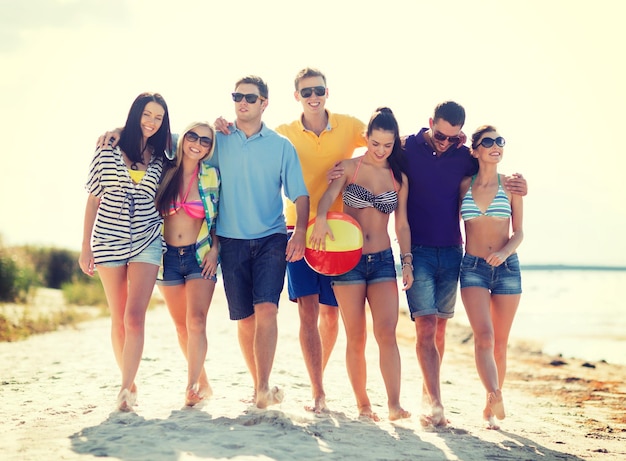 verano, vacaciones, vacaciones, concepto de gente feliz - grupo de amigos divirtiéndose con pelota en la playa