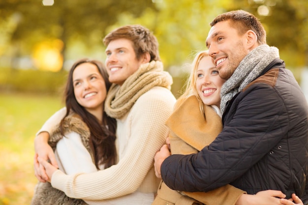 verano, vacaciones, vacaciones, concepto de gente feliz - grupo de amigos o parejas que se divierten en el parque de otoño