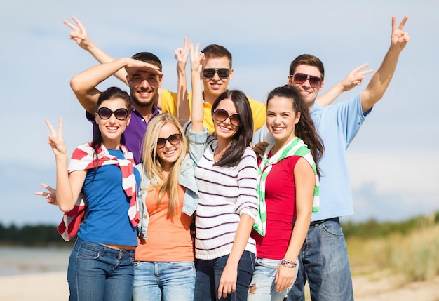 verano, vacaciones, vacaciones, gente feliz concepto - grupo de amigos divirtiéndose en la playa