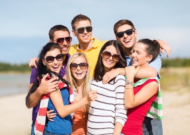 verano, vacaciones, vacaciones, gente feliz concepto - grupo de amigos divirtiéndose en la playa