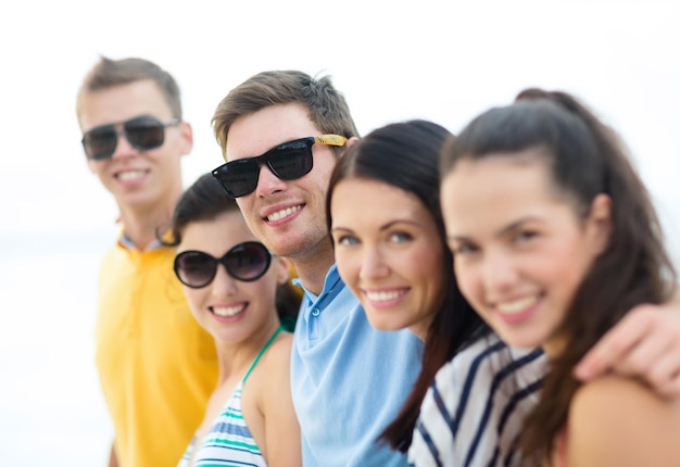 verano, vacaciones, vacaciones, gente feliz concepto - grupo de amigos divirtiéndose en la playa