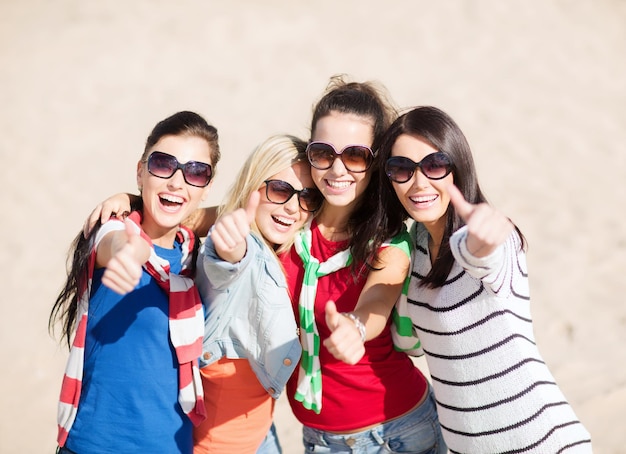 verano, vacaciones, vacaciones, gente feliz concepto - hermosas adolescentes o mujeres jóvenes que muestran los pulgares para arriba