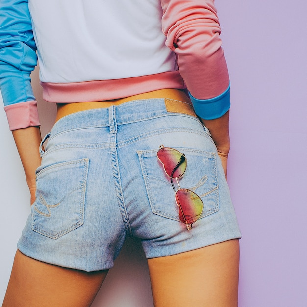 Foto verano de vainilla. modelo en una camiseta de moda y pantalones cortos de mezclilla, accesorios de moda gafas