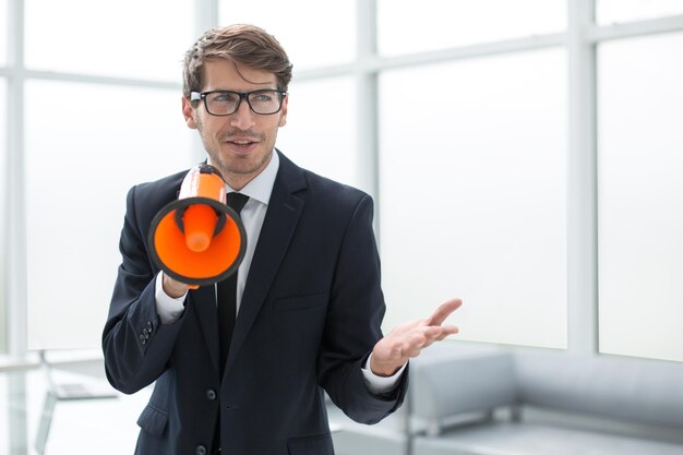 Foto verantwortlicher geschäftsmann mit megafon im bürodas konzept des managements