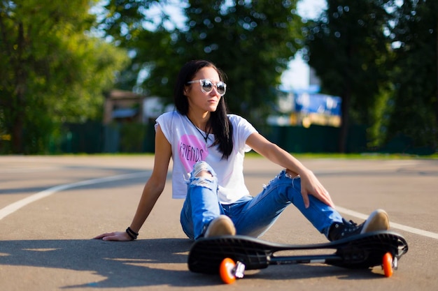 Verão a garota no parque andando de skate