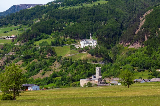 Verão alpino Burgeis Marienberg - castelo Fuerstenburg e Mosteiro da Abadia de Monte Maria (Kloster Marienberg) na colina atrás