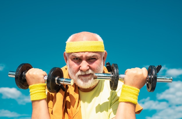 Foto verão e férias ativas como esportes desportista sênior levantamento de halteres homem idoso treino