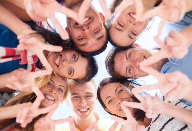 verão, feriados, férias, conceito de pessoas felizes - grupo de adolescentes olhando para baixo e mostrando o gesto do dedo cinco