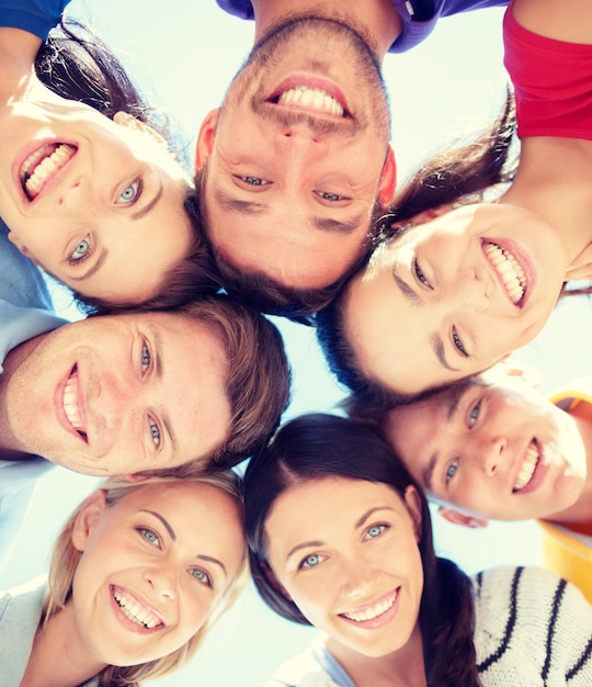 verão, feriados, férias, conceito de pessoas felizes - grupo de adolescentes olhando para baixo