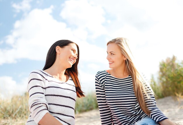 verão, feriados, férias, conceito de pessoas felizes - namoradas sorridentes se divertindo na praia