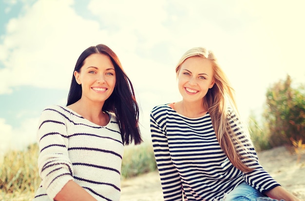 verão, feriados, férias, conceito de pessoas felizes - namoradas sorridentes se divertindo na praia