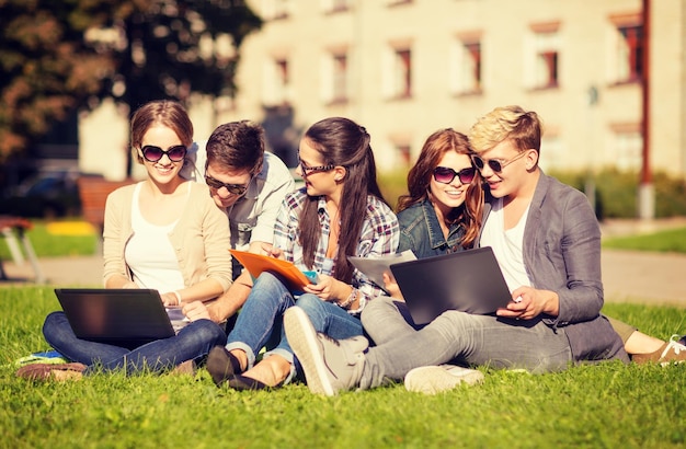 verão, internet, conceito de educação - grupo de estudantes ou adolescentes com laptop, notebooks, arquivos e pastas