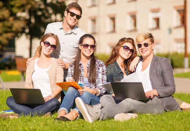 verão, internet, educação, campus e conceito adolescente - grupo de alunos ou adolescentes com laptop, notebooks, arquivos e pastas