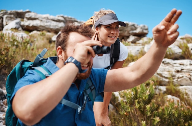 Verbinden Sie Fernglas und Wandern in den Bergen und genießen Sie die Aussicht auf Bewegung und Fitness in der Natur beim Trekking Freedom Rock und Frau mit Ma-Rucksack und Training für Gesundheits- und Wellnessreisen im Freien