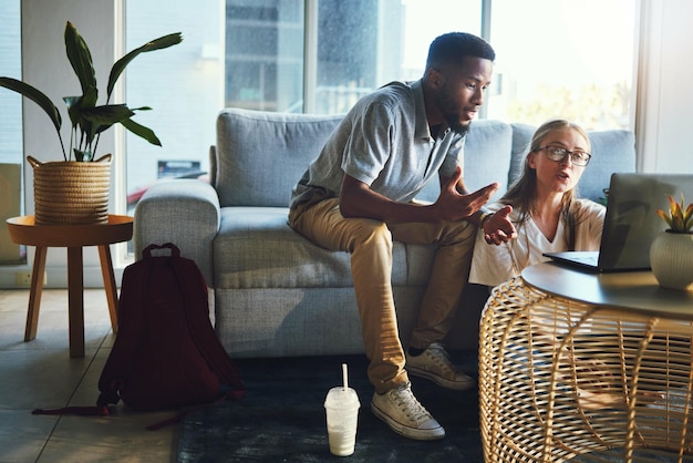 Verbinden Sie Laptop und Schulden, während Sie auf der Couch im Wohnzimmer über Remote-Arbeitsrechnungen oder E-Mails mit WLAN zu Hause sprechen