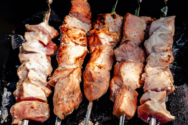 Verbrannte Schweinefleischspieße auf Eisengrill im Freien, Nahaufnahme ...