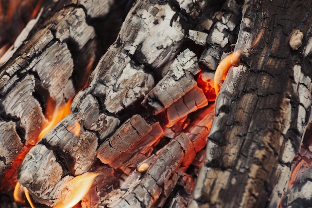 Foto verbranntes holz und ein bisschen feuer aus nächster nähe dunkle kohlen des großen lagerfeuers konzept des ausbrennens, das den tod beendet