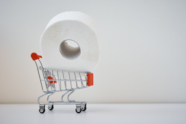 Verbraucher kaufen Panik über Coronavirus Covid-19-Konzept. Toilettenpapierrolle im Einkaufswagen mit Inschriftenstopp-Panik.