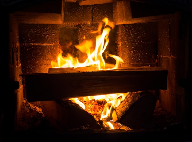 Verbrennen von Brennholz in einem Kamin in einem Landhaus. Rustikaler Ofen mit brennenden Holzscheiten aus nächster Nähe.