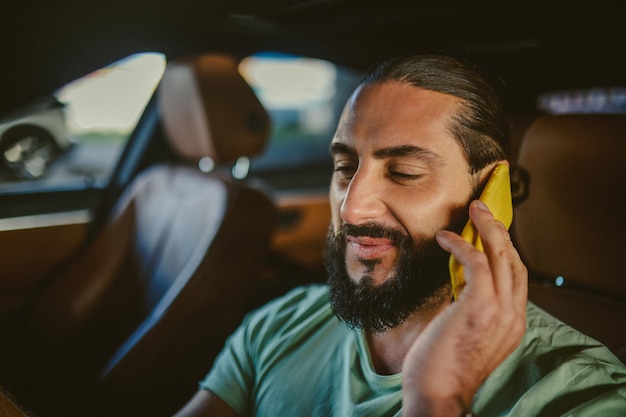 Verbunden Junger gutaussehender dunkelhaariger Mann mit einem Telefon in der Hand