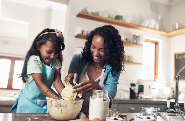 En verdad, una familia es lo que tú haces de ella Fotografía de una mujer horneando en casa con su hija pequeña