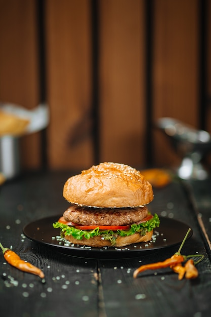 Verdadera hamburguesa clásica en una mesa de madera oscura