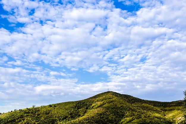 Verde colina alta y cielo nublado