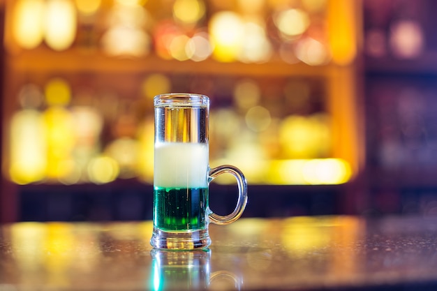 Verde mexicano en el bar. Cóctel alcohólico ardiente multicapa. De cerca