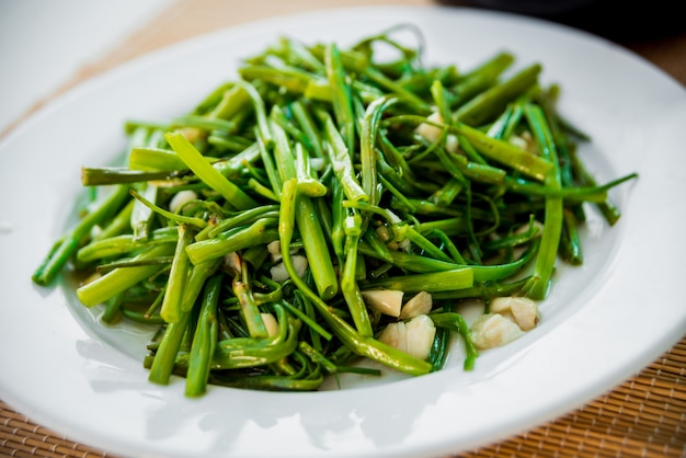 Verdes cozidos com arroz no prato branco.