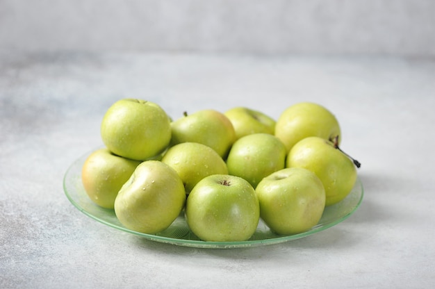 Verdes jugosas manzanas enteras en un plato