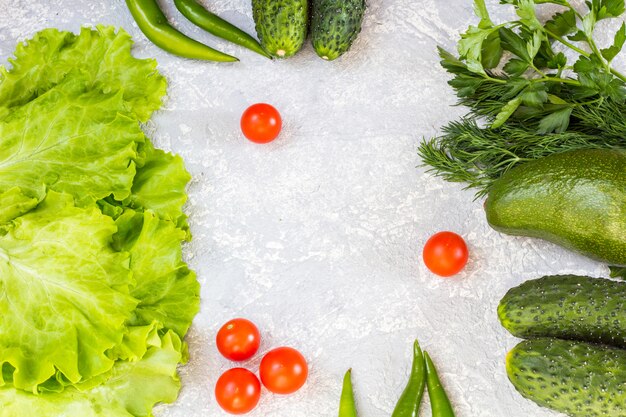 Foto verdes suculentos e tomate cereja em um cinza