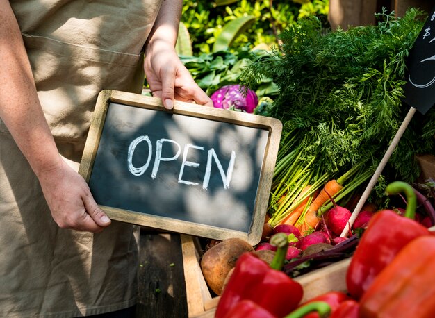 Foto verdulero que vende productos agrícolas frescos orgánicos en el mercado agrícola