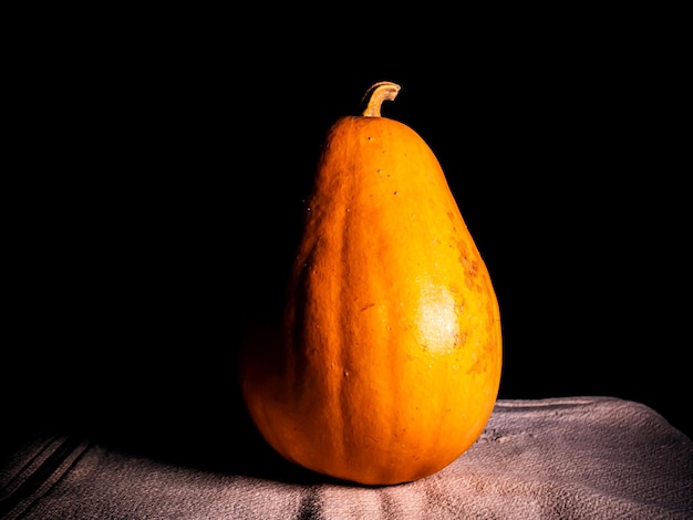 Verdura de calabaza naranja sobre un fondo negro