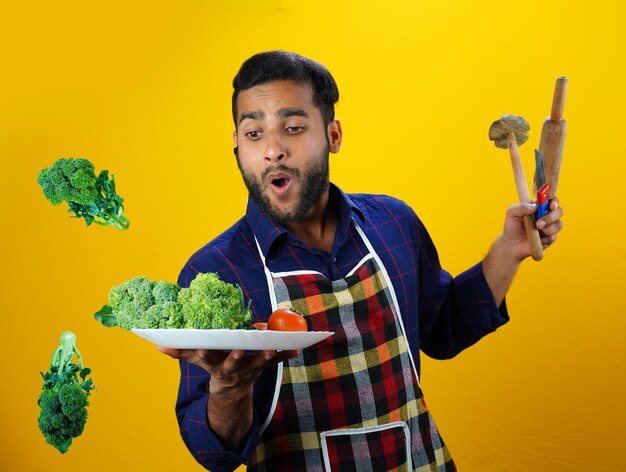 Verduras en el aire Joven chef Boy Imágenes aisladas con delantal comida o concepto de gestión hotelera