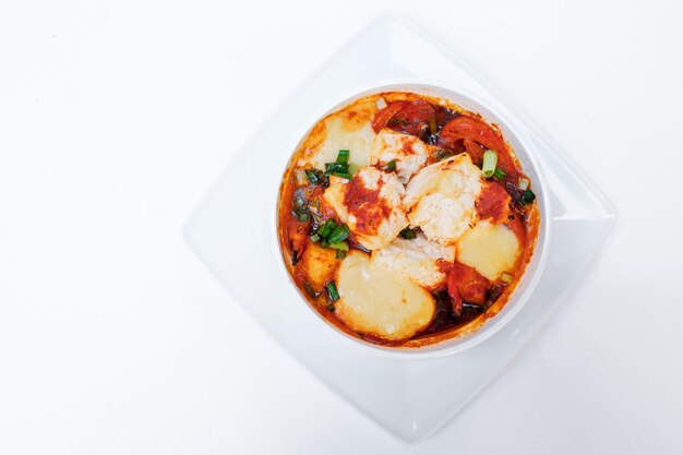 Verduras al horno calabacín y tomates con queso. Aislado en blanco por trazado de recorte. De cerca