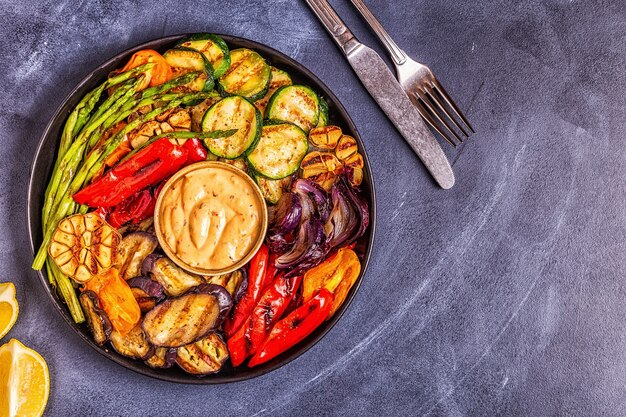 Verduras asadas en un plato con salsa