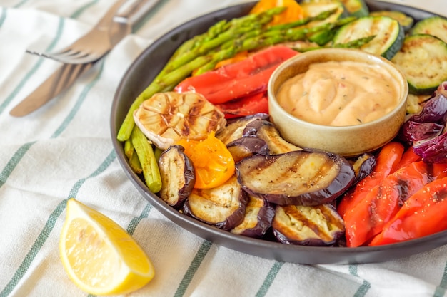 Verduras asadas en un plato con salsa