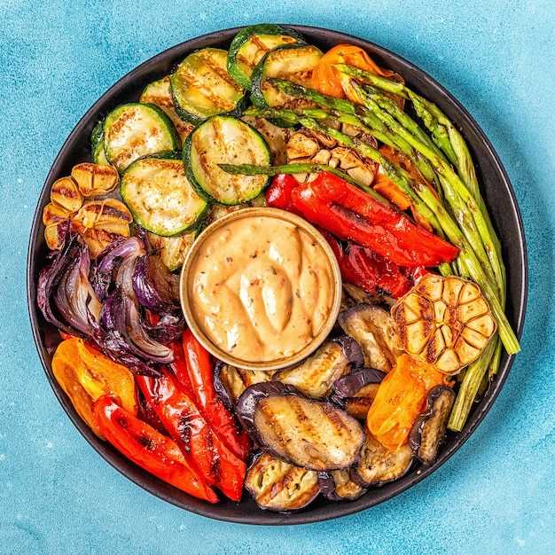 Verduras asadas en un plato con salsa