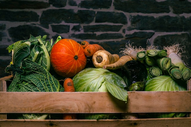 Foto verduras en una caja cerca del fondo col zanahoria berenjena puerro calabaza